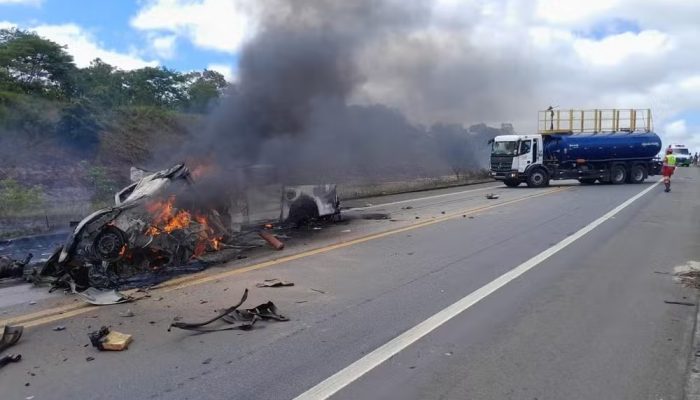 Carro totalmente destruído e em chamas após acidente em um trecho da BR-101 que corta o municí...