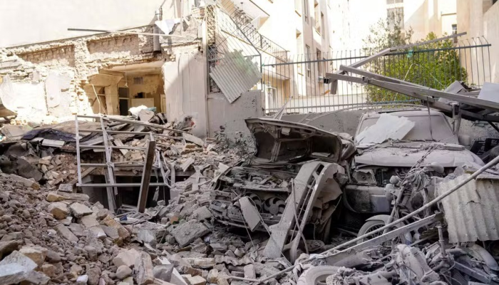 Escombros e destroços cobrem um veículo destruído após um ataque com mísseis a um bairro da ...